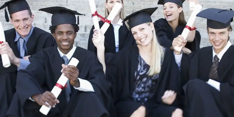 Group of Graduates Sitting and Holding Up Diplomas